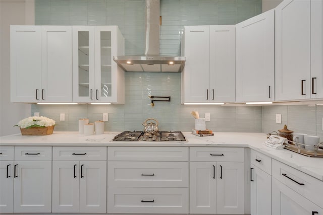 kitchen featuring white cabinetry, wall chimney exhaust hood, stainless steel gas stovetop, and tasteful backsplash