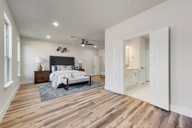 bedroom with ceiling fan, connected bathroom, and light wood-type flooring