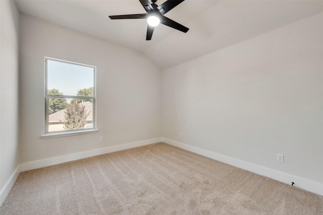 empty room featuring lofted ceiling, light carpet, and ceiling fan