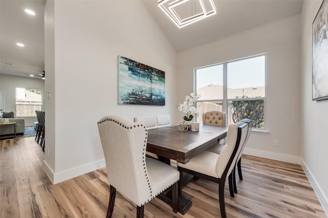 dining area featuring ceiling fan, lofted ceiling, and light wood-type flooring