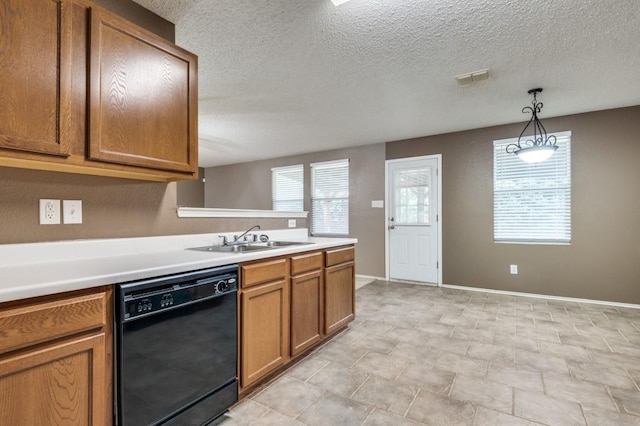 kitchen featuring pendant lighting, dishwasher, sink, and a textured ceiling