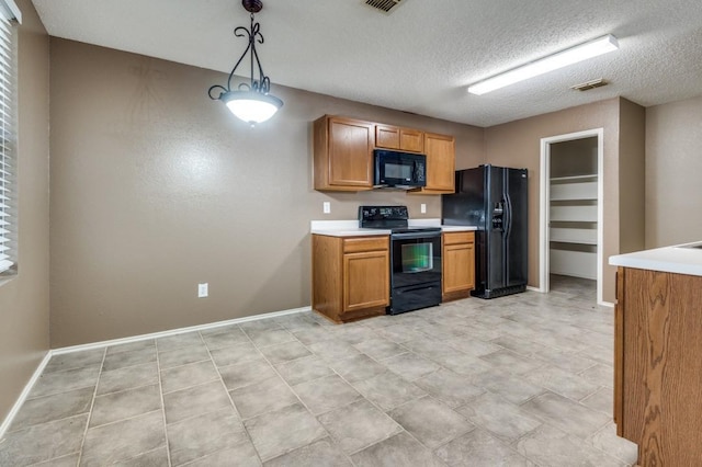 kitchen featuring decorative light fixtures, a textured ceiling, and black appliances