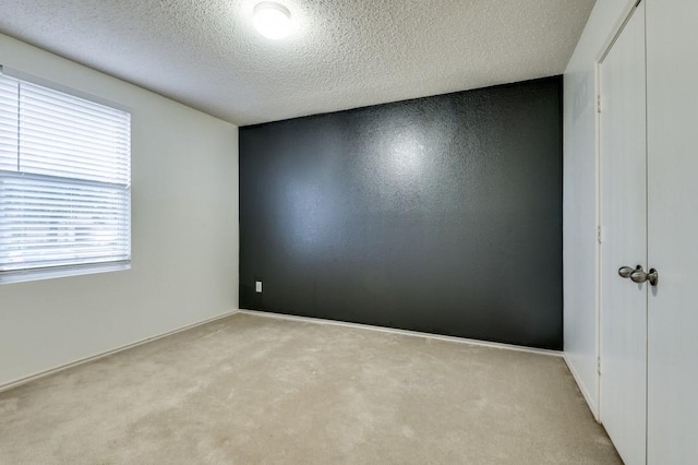 carpeted spare room featuring a textured ceiling