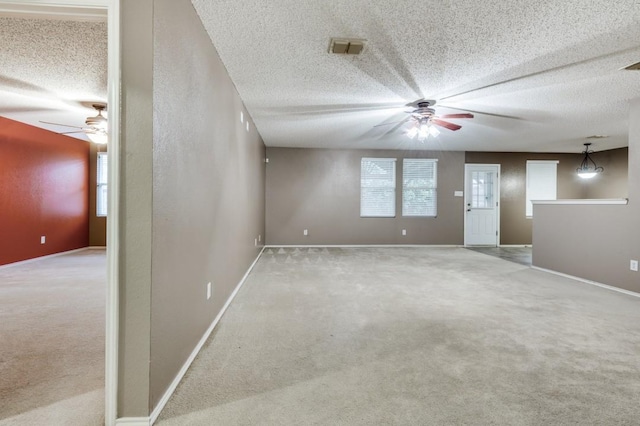 carpeted empty room featuring ceiling fan and a textured ceiling