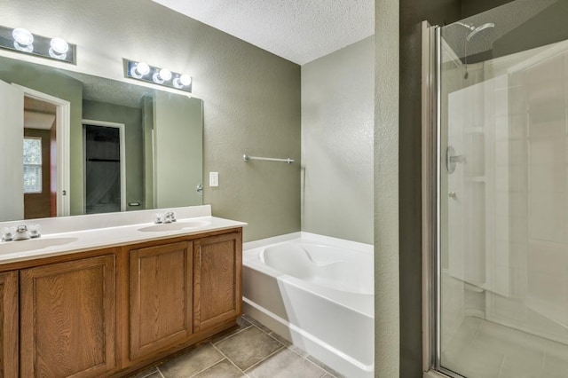 bathroom with tile patterned flooring, vanity, plus walk in shower, and a textured ceiling