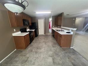 kitchen featuring black appliances, kitchen peninsula, and sink