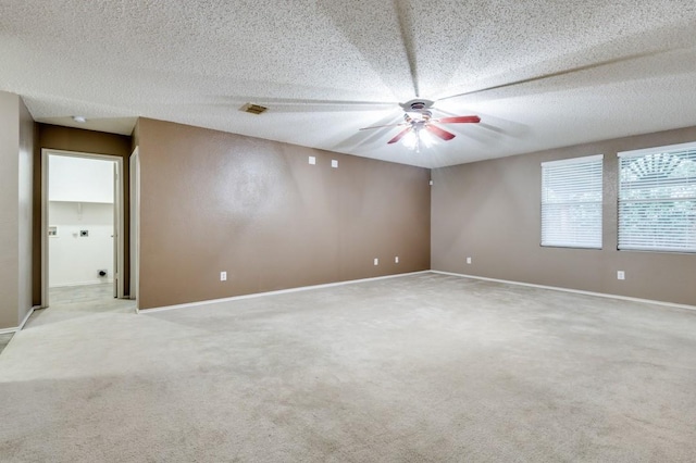 carpeted empty room featuring ceiling fan and a textured ceiling