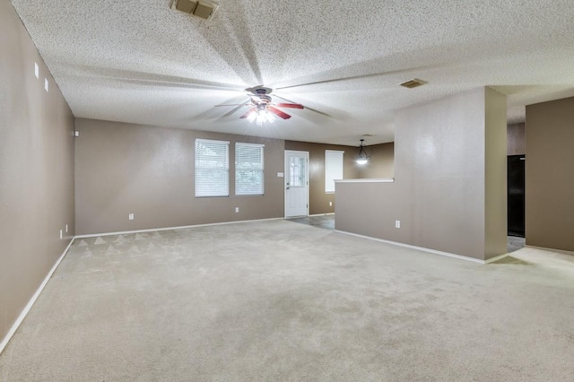 empty room with light colored carpet and a textured ceiling