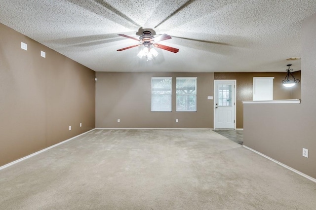 spare room featuring ceiling fan, a textured ceiling, and carpet flooring