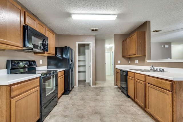 kitchen with sink, a textured ceiling, and black appliances