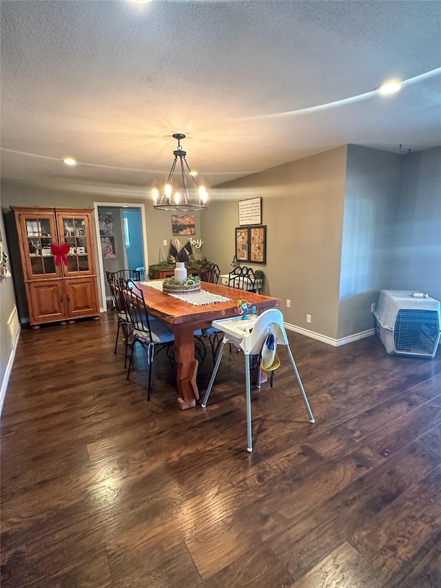 dining space featuring an inviting chandelier, dark hardwood / wood-style floors, and a textured ceiling