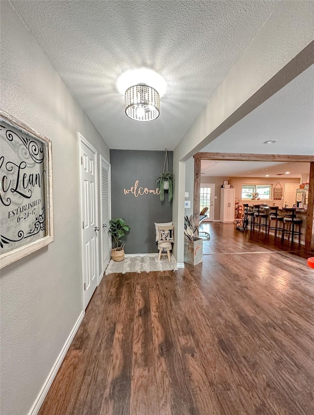 hall featuring hardwood / wood-style floors, a chandelier, and a textured ceiling