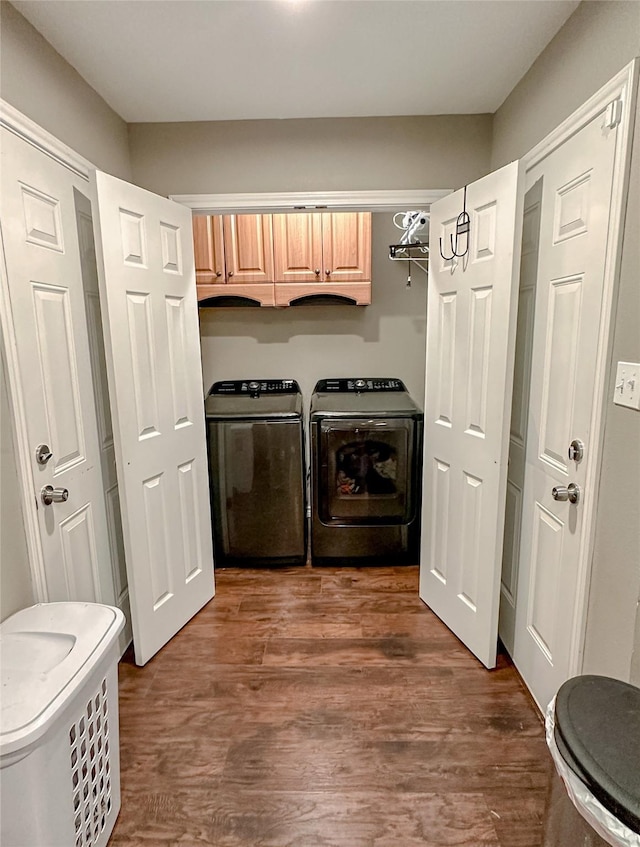 laundry room featuring cabinets, independent washer and dryer, and dark hardwood / wood-style flooring