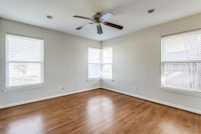 empty room with hardwood / wood-style floors and ceiling fan