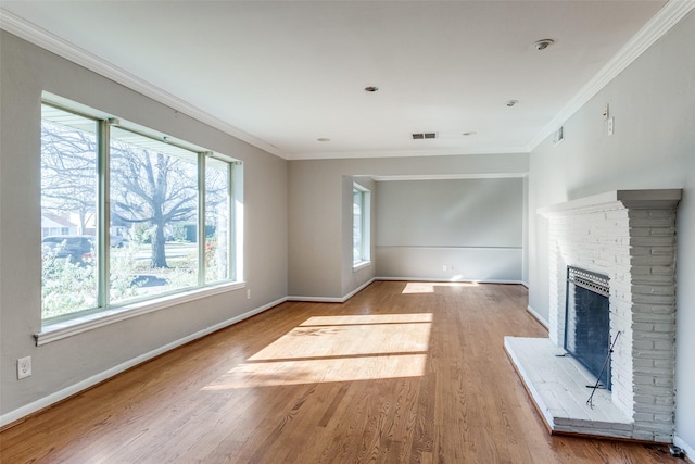 unfurnished living room featuring light hardwood / wood-style floors, a brick fireplace, heating unit, and ornamental molding