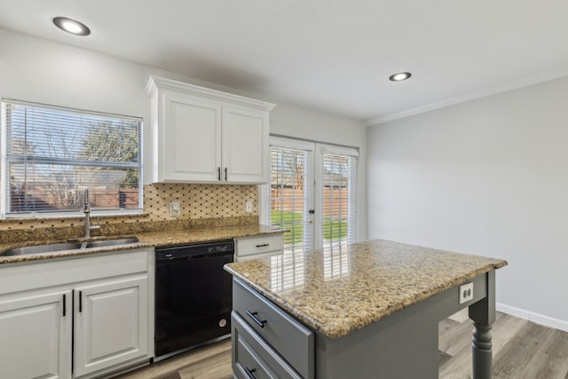 kitchen with a center island, sink, white cabinets, and black dishwasher