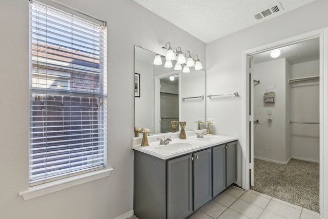 bathroom with vanity, a textured ceiling, and tile patterned flooring