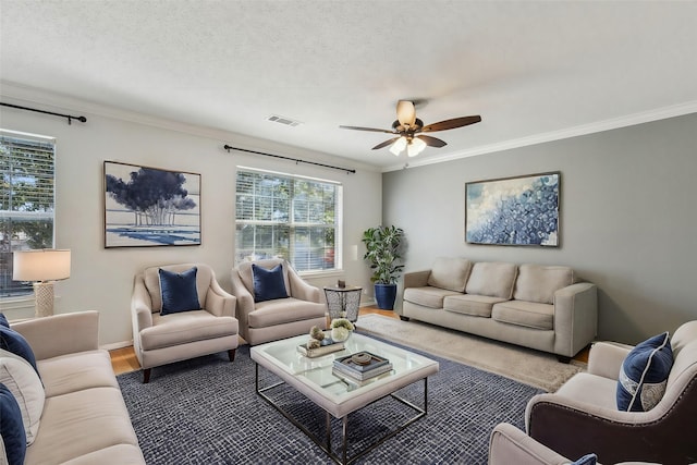 sitting room with carpet, a textured ceiling, ceiling fan, and crown molding