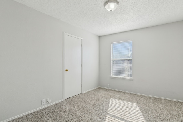 carpeted empty room featuring a textured ceiling