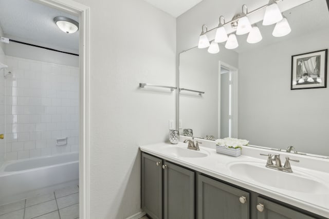 bathroom with tile patterned flooring, vanity, and tiled shower / bath