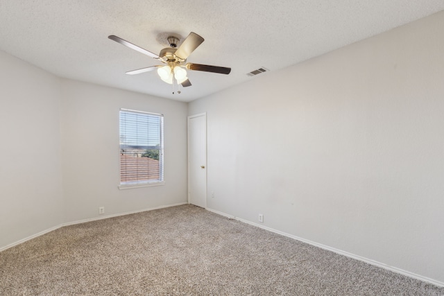 carpeted spare room featuring ceiling fan and a textured ceiling