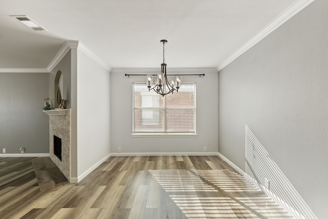 unfurnished dining area featuring wood-type flooring, a chandelier, and ornamental molding