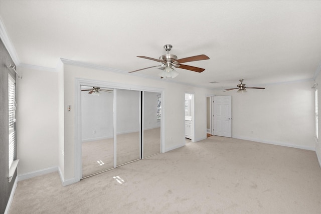 unfurnished bedroom featuring ceiling fan, baseboards, crown molding, and light colored carpet