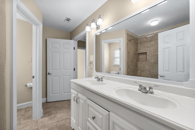 full bath with visible vents, a sink, toilet, and double vanity