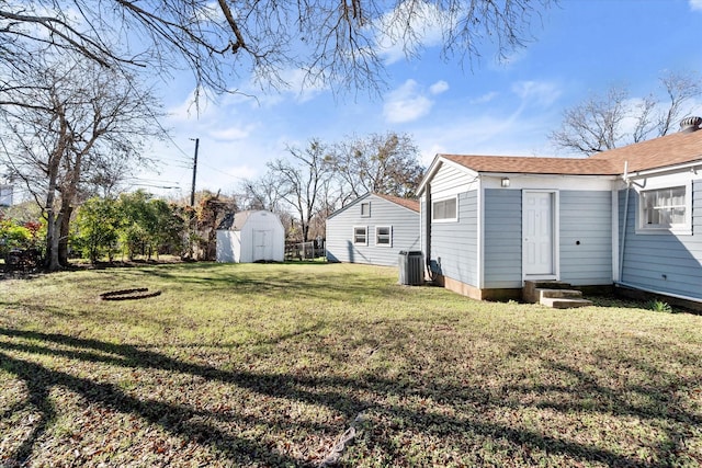 view of yard with entry steps, central AC, a shed, and an outdoor structure