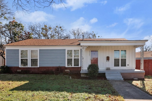 view of front of house with brick siding, board and batten siding, and a front yard