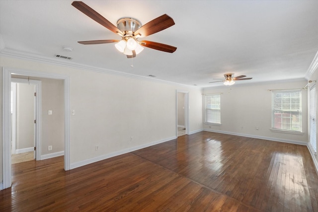 spare room featuring baseboards, visible vents, dark wood-style floors, ceiling fan, and crown molding