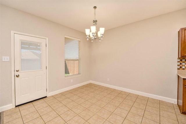 unfurnished dining area featuring light tile patterned floors and a notable chandelier