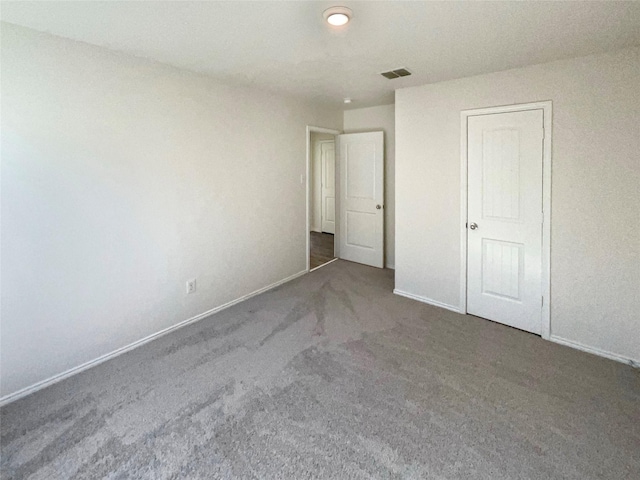 unfurnished bedroom with dark colored carpet