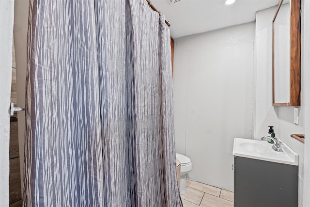 bathroom featuring tile patterned floors, walk in shower, vanity, and toilet