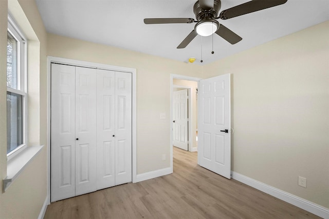 unfurnished bedroom with a closet, ceiling fan, and light wood-type flooring