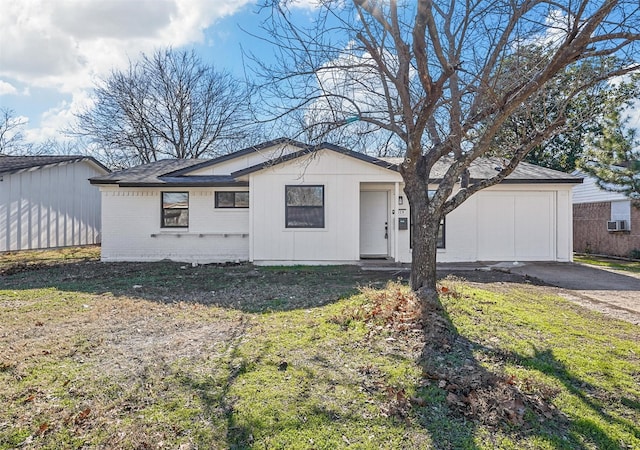 ranch-style house featuring a garage, cooling unit, and a front lawn