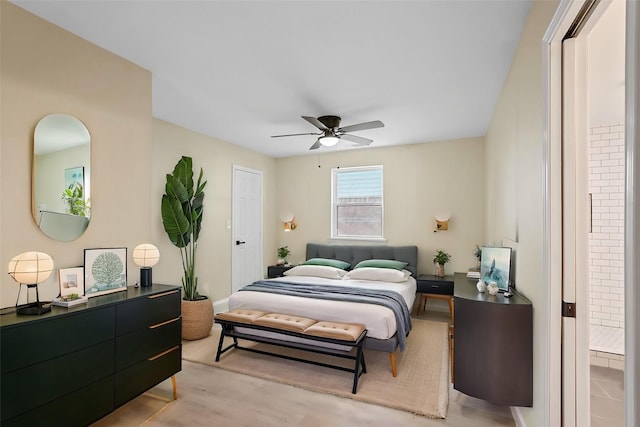 bedroom featuring ceiling fan, ensuite bathroom, and light hardwood / wood-style floors