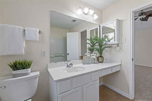 bathroom with toilet, vanity, and tile patterned floors