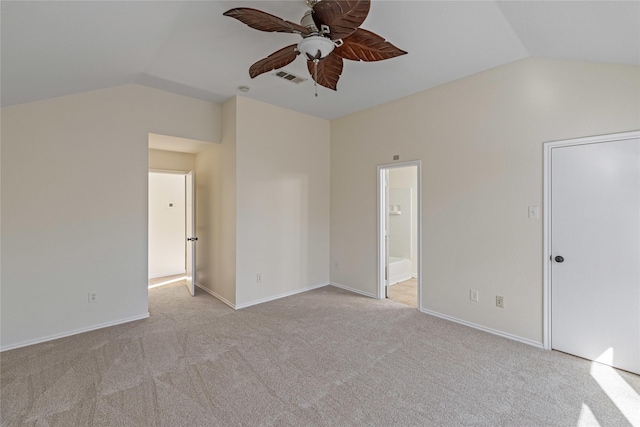 interior space featuring light carpet, connected bathroom, vaulted ceiling, and ceiling fan