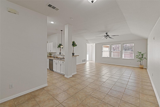 unfurnished living room featuring ceiling fan, sink, light tile patterned floors, and vaulted ceiling