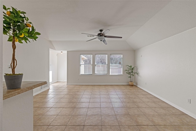 empty room featuring ceiling fan, light tile patterned flooring, and lofted ceiling