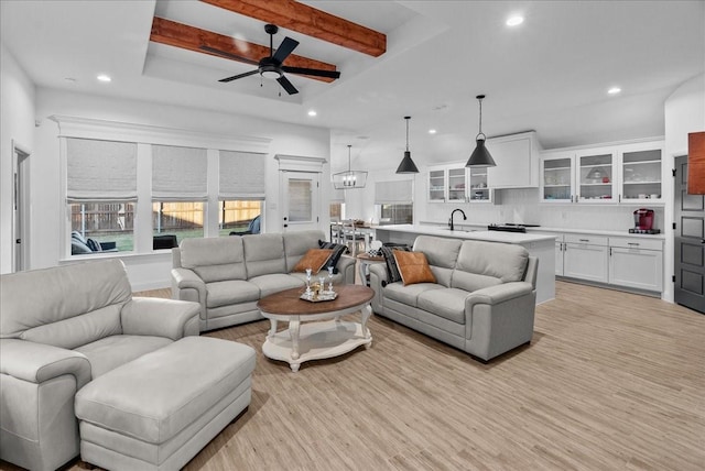 living area with beam ceiling, recessed lighting, light wood-style flooring, and ceiling fan