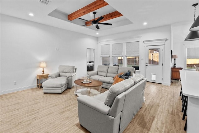 living area with visible vents, baseboards, beam ceiling, light wood-style flooring, and ceiling fan