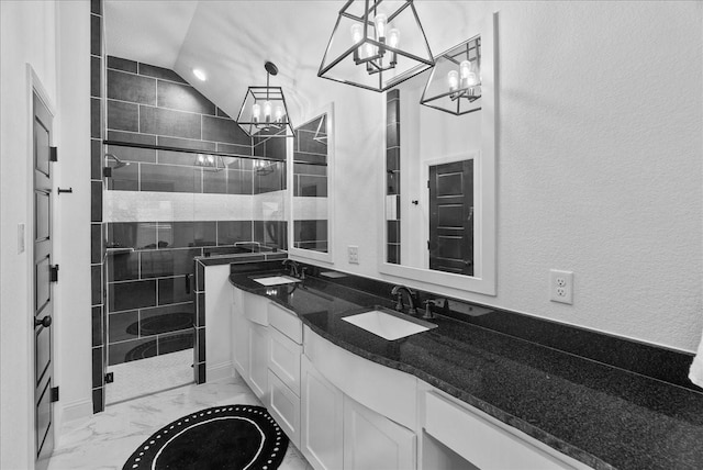 bathroom with a shower stall, a notable chandelier, marble finish floor, and a sink