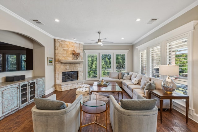 living room featuring a stone fireplace, dark hardwood / wood-style flooring, and ornamental molding