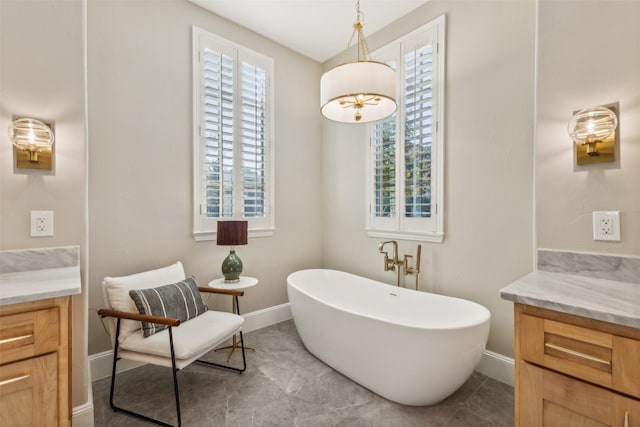 bathroom with a wealth of natural light, vanity, and a bathtub