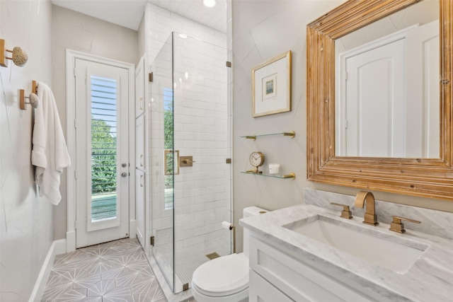 bathroom featuring tile patterned flooring, a shower with door, vanity, and toilet