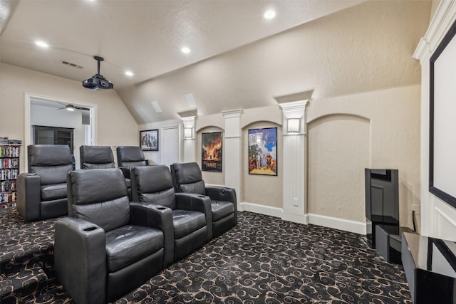 home theater room with ceiling fan, dark carpet, and lofted ceiling