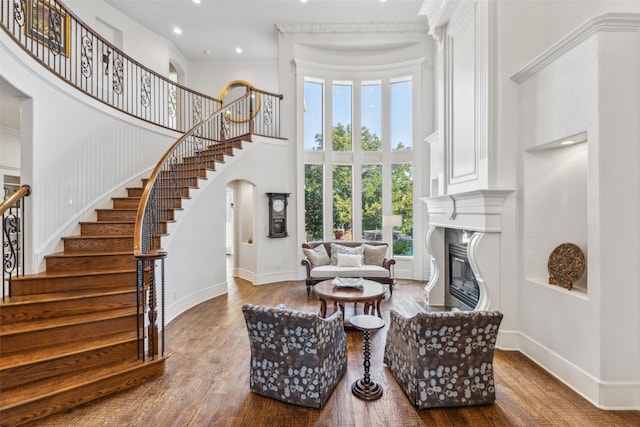 sitting room with a high ceiling and hardwood / wood-style flooring