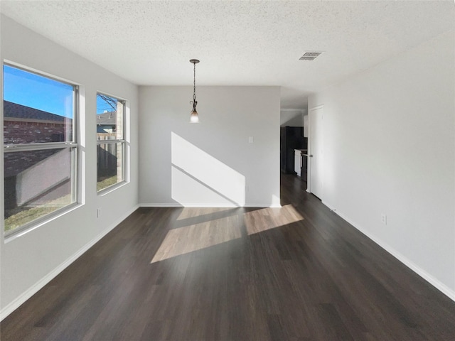 unfurnished room featuring dark hardwood / wood-style flooring and a textured ceiling